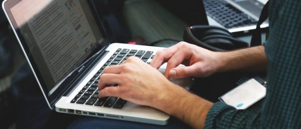 Developer typing code on a laptop while weighing gpt-6 sol against claude opus 5. 5 for coding work
