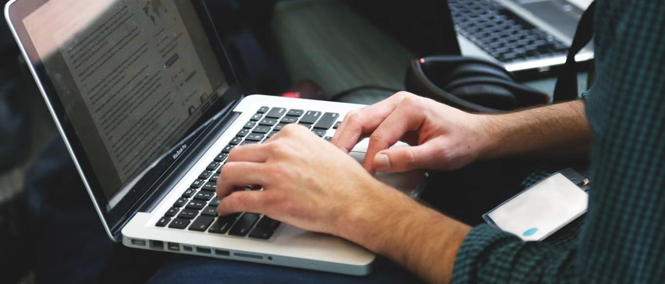 Developer typing code on a laptop while weighing GPT-6 Sol against Claude Opus 5.5 for coding work